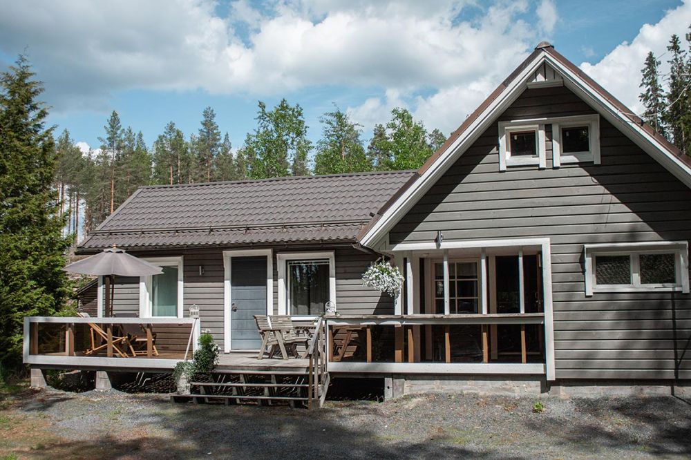 Kuva harmaaksi maalatun mökin julkisivusta