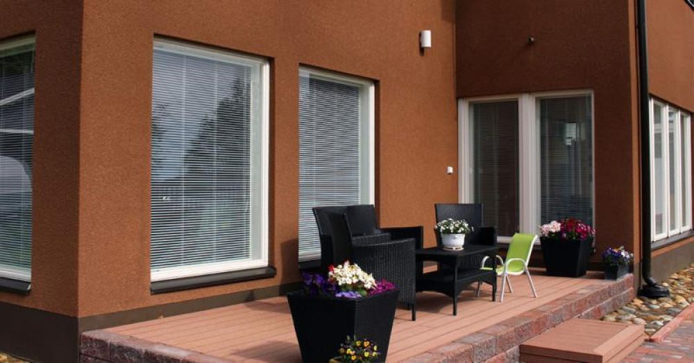 Kivitalo, jonka eteläisen julkisivun ikkunoissa on auringonsuojalasi